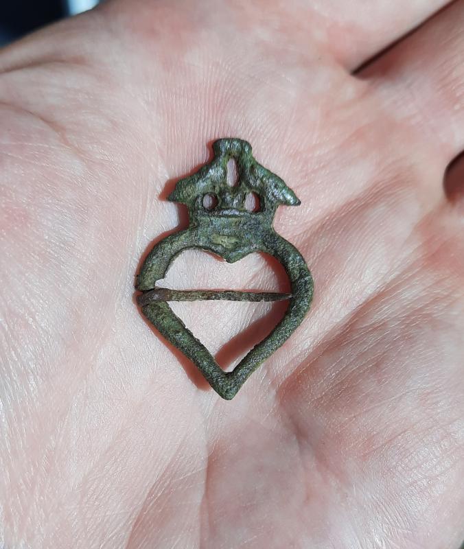 13th or 14th century annular brooch depicting 2 kissing birds over a heart