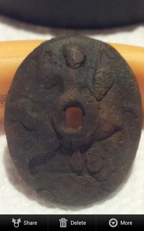 1700's era colonial sword pommel end , depicting an embossed rendition of St. George on horseback slaying the dragon beneath .