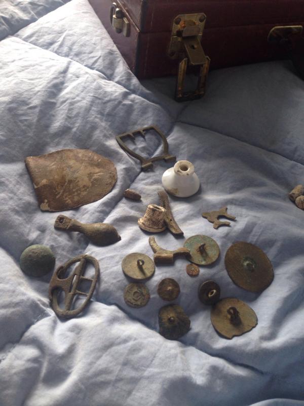 Closer view of relics from the same cellar hole in another picture. Included are buttons. lead thing, silver plated buckle piece. knee buckle, porcela